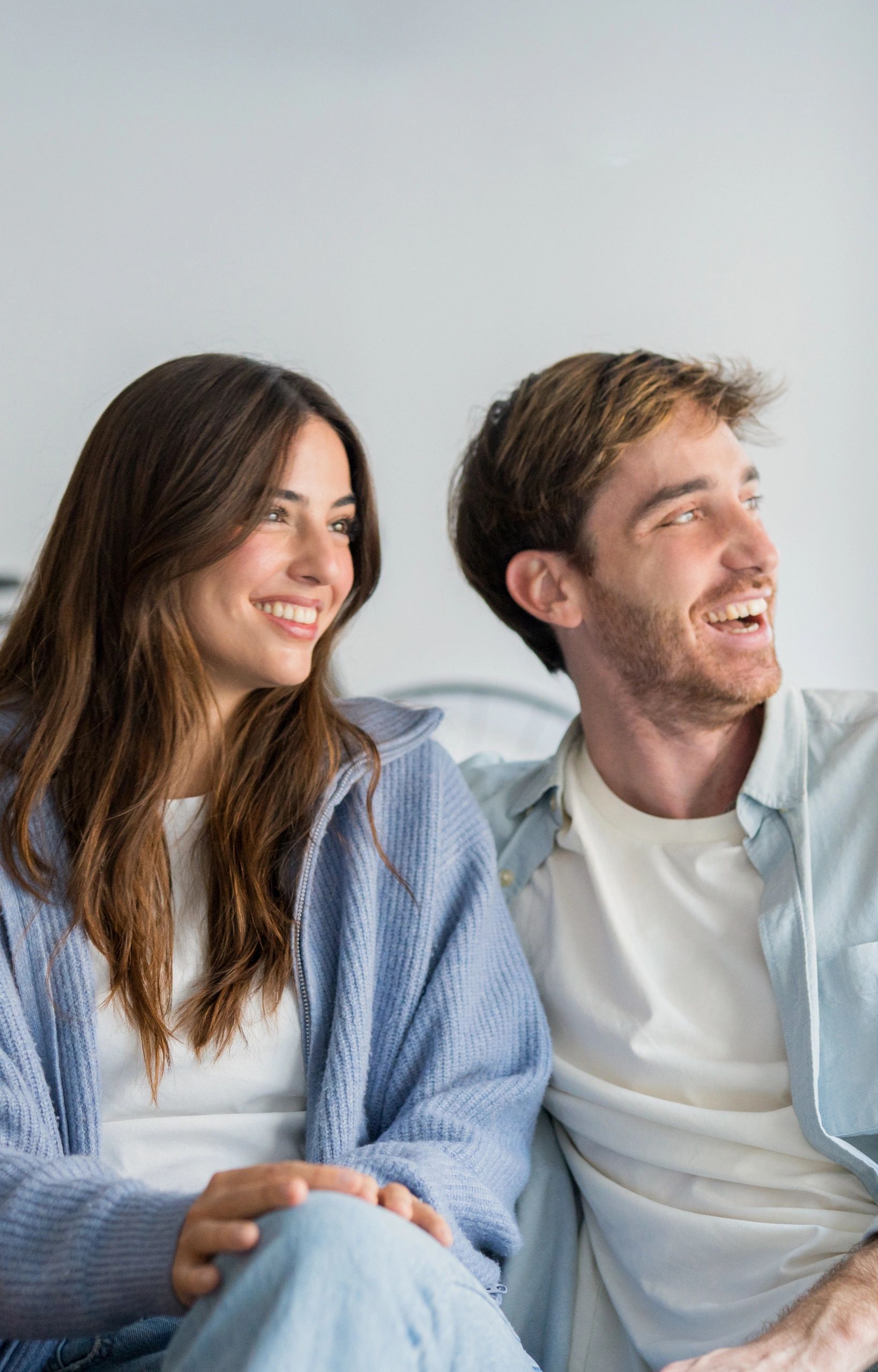 Pareja sonriendo en un ambiente íntimo y moderno
