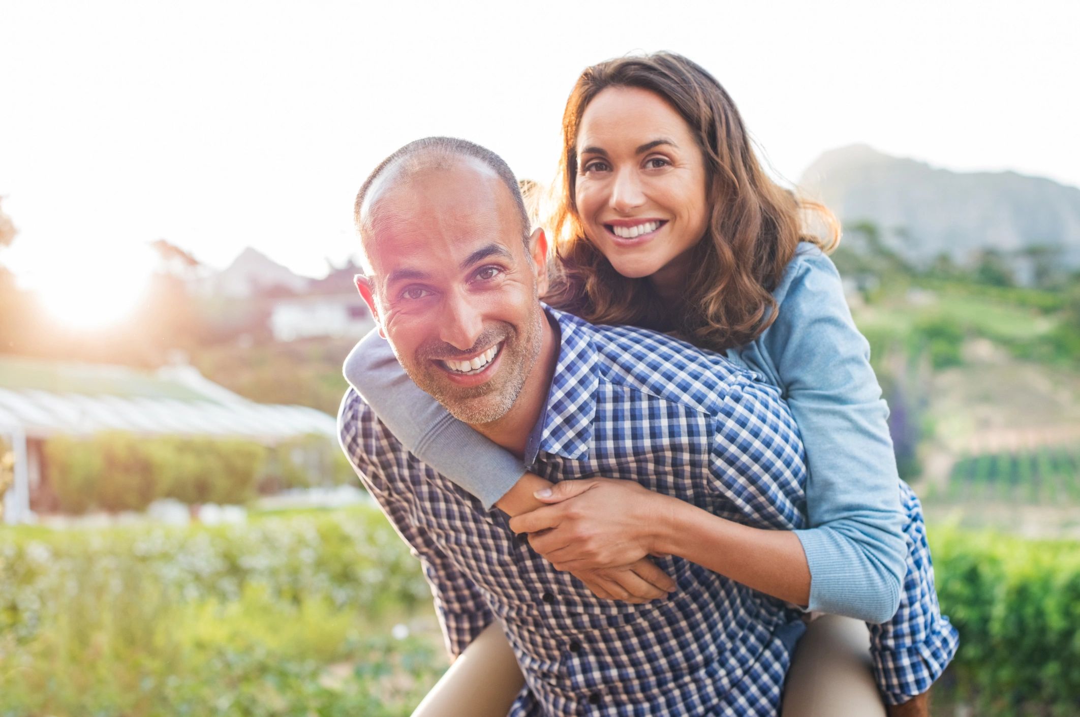 Pareja adulta sonriendo al aire libre, representando bienestar, confianza e intimidad saludable